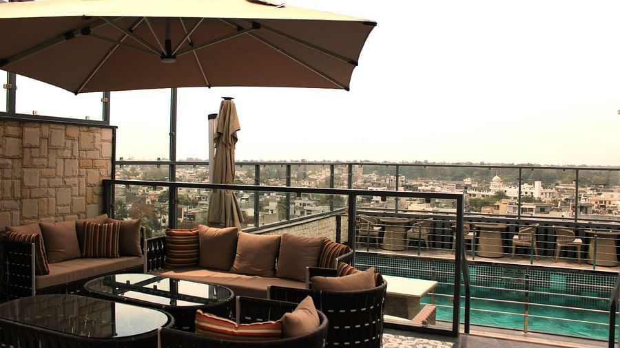 A rooftop lounge with a spacious patio and an adjacent swimming pool at BluSalzz Residence, Amritsar